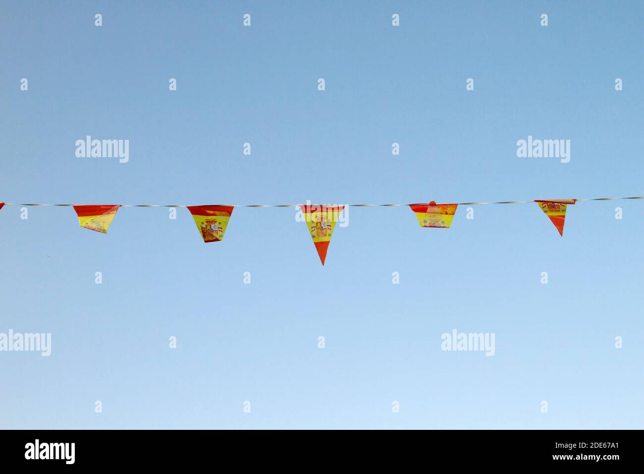 Espagne drapeaux en plastique et fond bleu ciel Banque D'Images