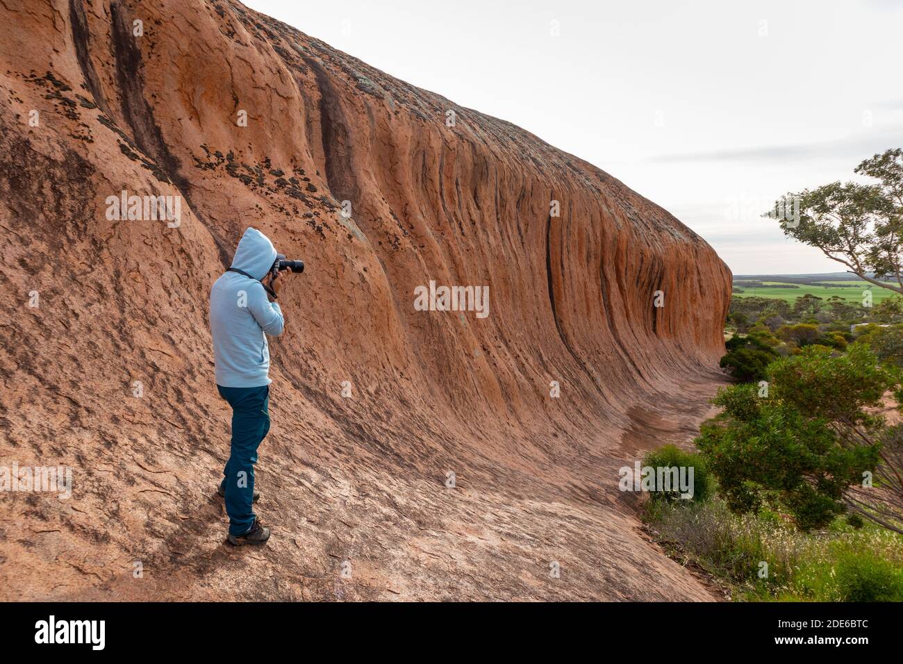 Touriste mâle prenant des photos de la roche de Pildappa, de la roche ondulée en Australie riche en granites roses. Place de camping et aire de pique-nique au bord de la roche. Péninsule d'Eyre Banque D'Images