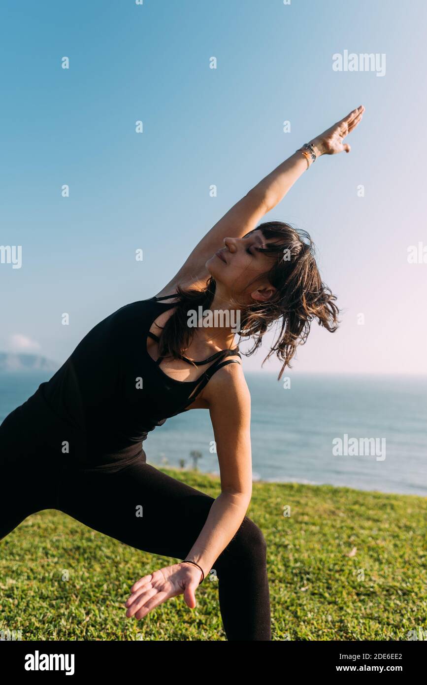 Portrait d'une femme vêtue de noir en plein air pratique le yoga. Copier l'espace Banque D'Images