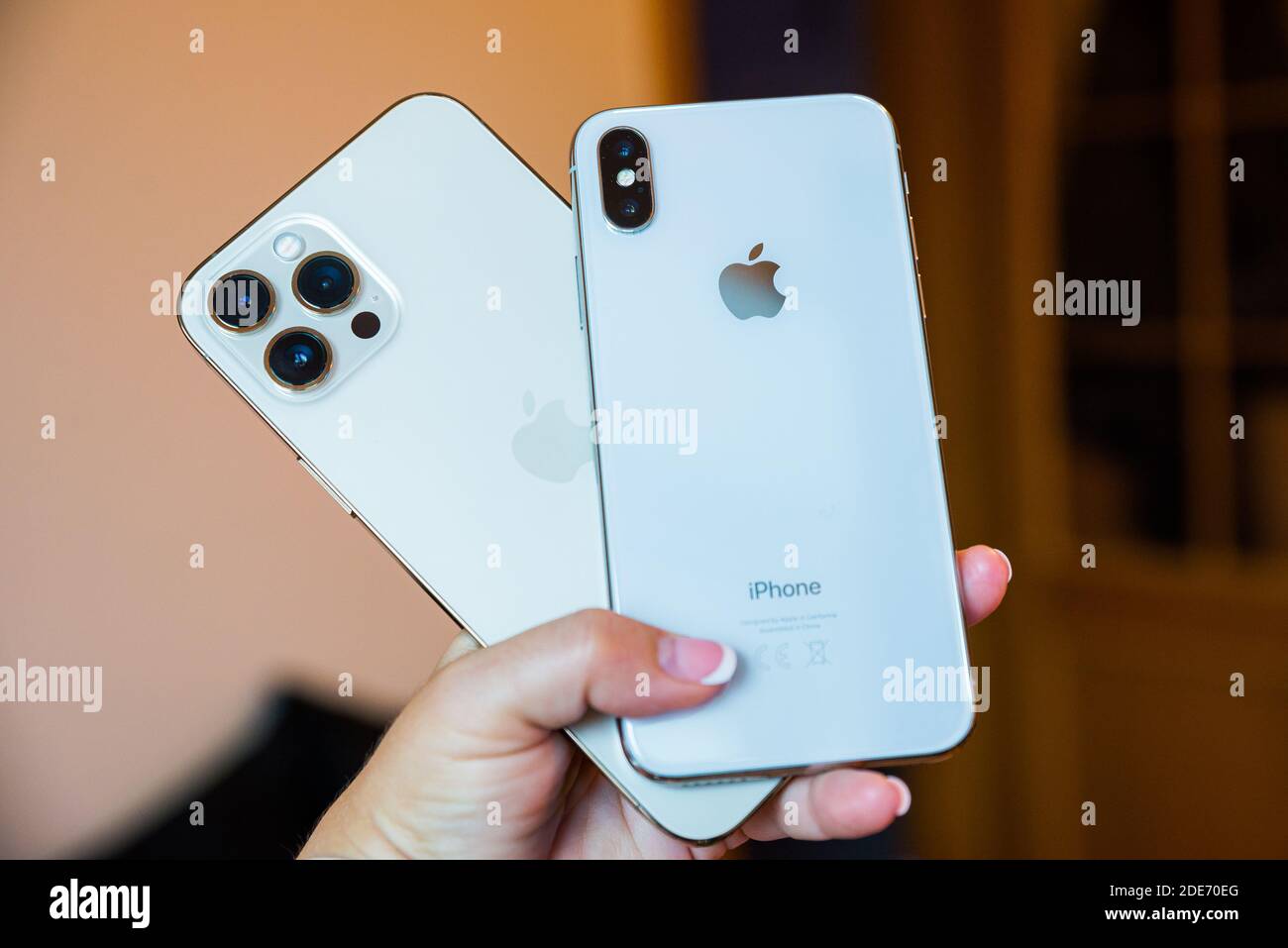 Prague, République tchèque - 24 novembre 2020. Nouvel iPhone 12 Pro Max et l'ancien iPhone X dans la petite main de femme Banque D'Images