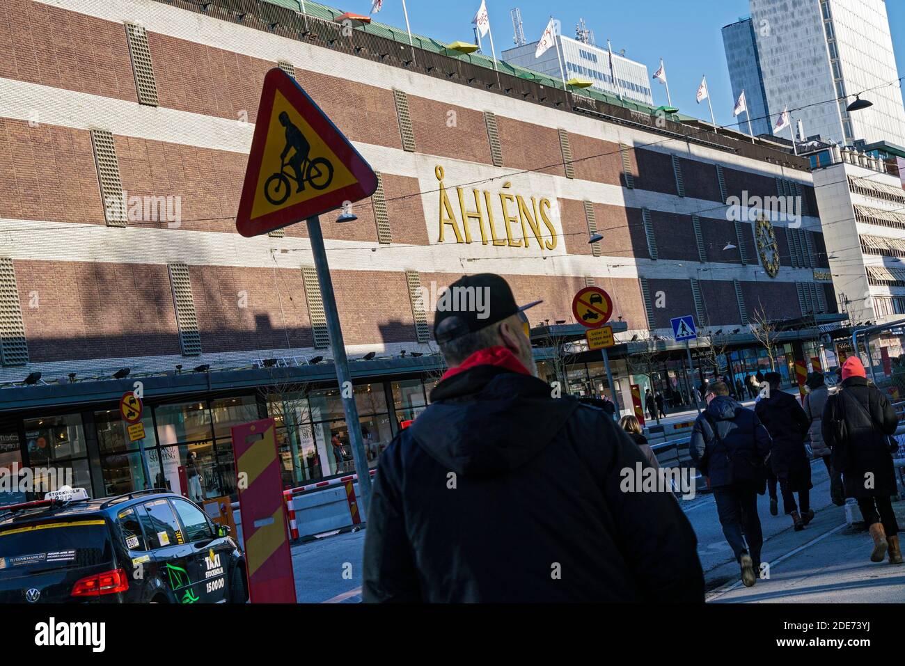 Stockholm - 02/07/2017: Homme de l'arrière marchant à Klarabergsviadukten pendant l'hiver en face du centre commercial Ahlens Banque D'Images