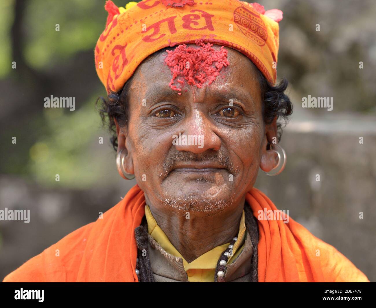 Vieux népalais hindou Gorakhnathi yogi moine avec de grandes boucles d'oreilles dans son cartilage d'oreille coupée et le riz rouge marque tilak sur son front pose pour la caméra. Banque D'Images