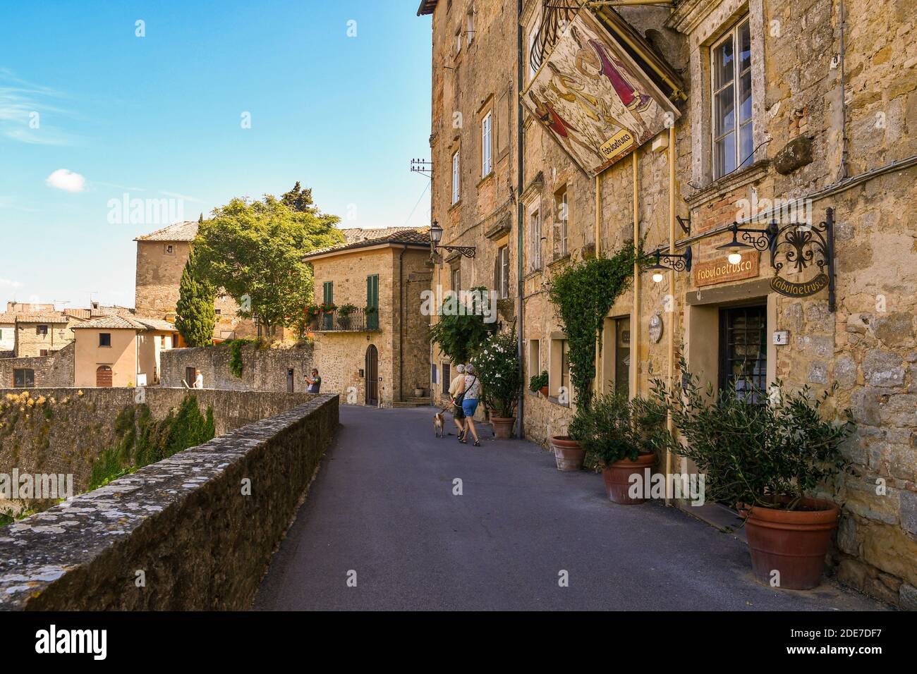 Une ruelle étroite dans le centre historique de l'ancienne ville étrusque de Volterra avec les maisons typiques en pierre et en brique en été, Pise, Toscane, Italie Banque D'Images