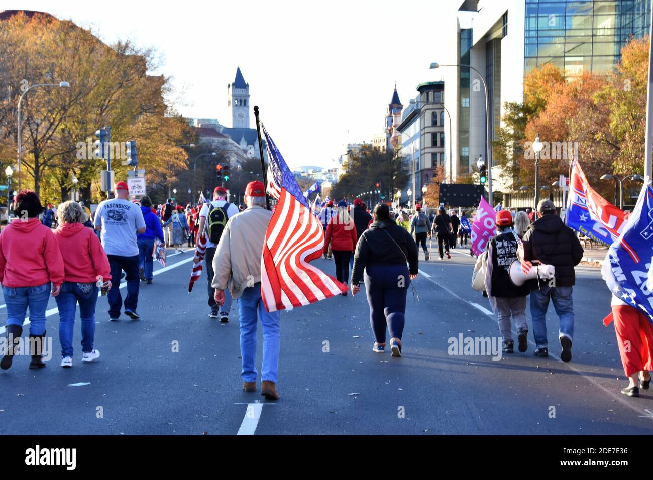 Washington DC. Novembre 14,2020. La marche de Mages. Vue arrière d'un homme portant le drapeau américain avec des personnes marchant dans la rue en direction de Freedom plaza Banque D'Images