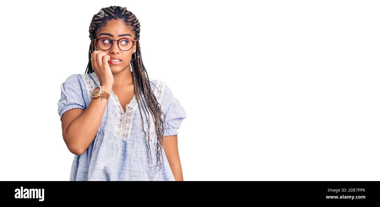 Jeune afro-américaine femme avec des tresses portant des vêtements et des lunettes décontractés d'été et ayant l'air stressée et nerveuse avec les mains sur la bouche mordant les ongles. anxi Banque D'Images