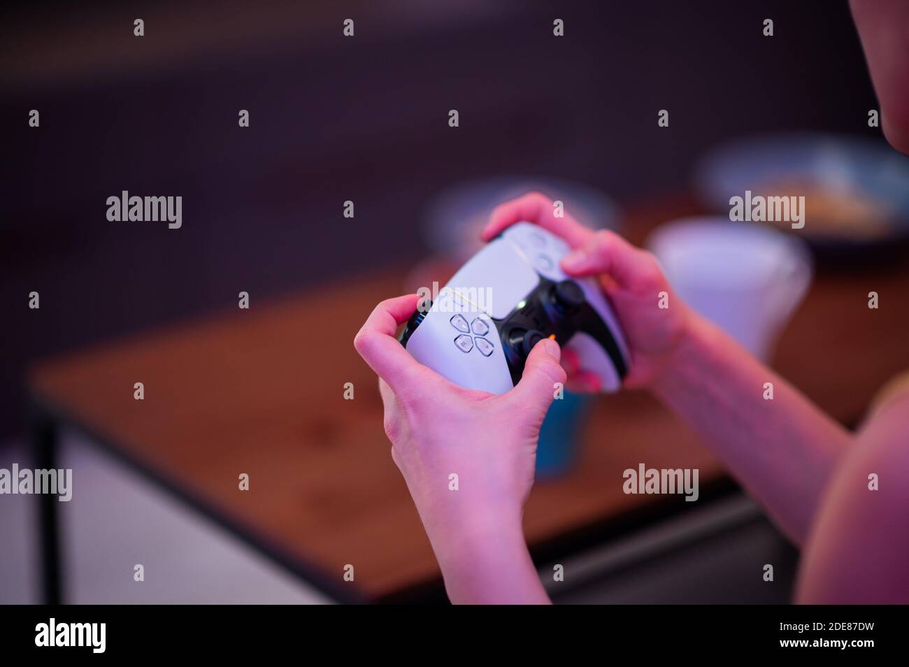 Fille avec contrôleur de prochaine génération dans ses mains jouant à des jeux à la maison. Banque D'Images