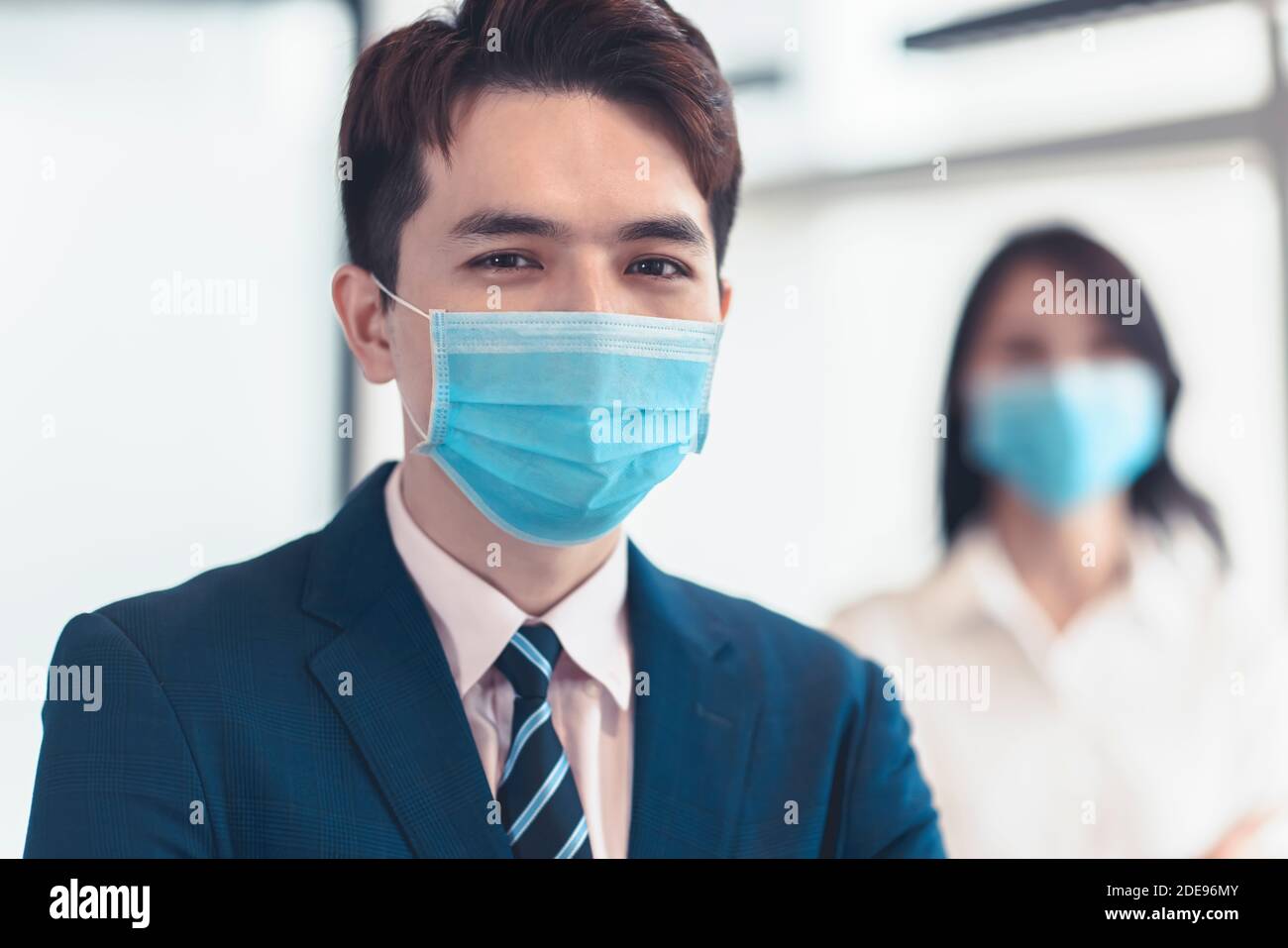 Les gens d'affaires portant un masque médical lorsqu'ils travaillent au bureau Banque D'Images