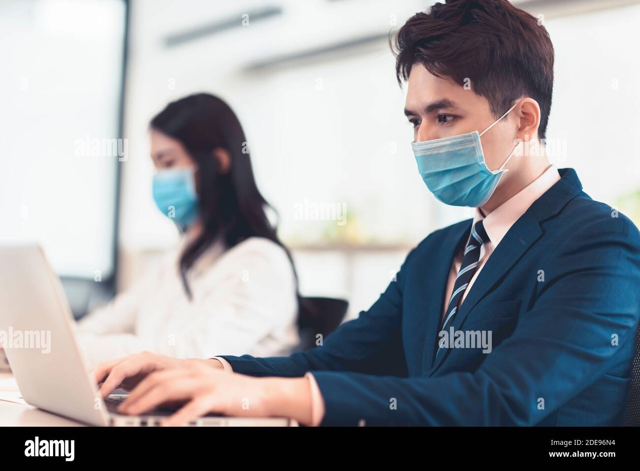 Les gens d'affaires portant un masque médical lorsqu'ils travaillent au bureau Banque D'Images