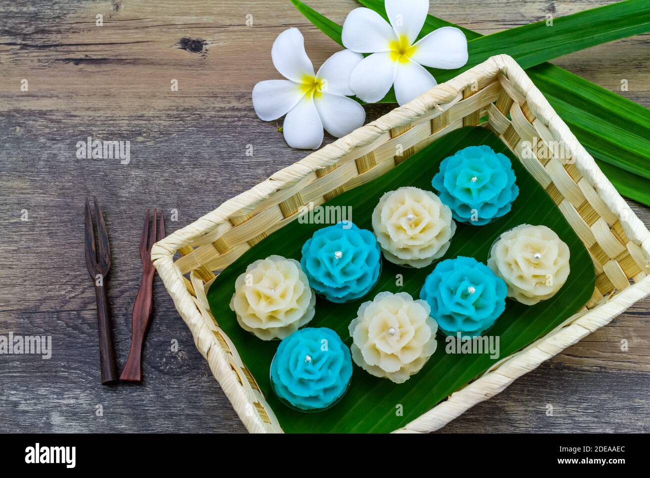 Dessert thaï traditionnel de la forme de fleur substance avec le soja écrasé et le taro (nom thaï kanom Chor phaka) dans le panier de bambou sur fond de bois. Banque D'Images