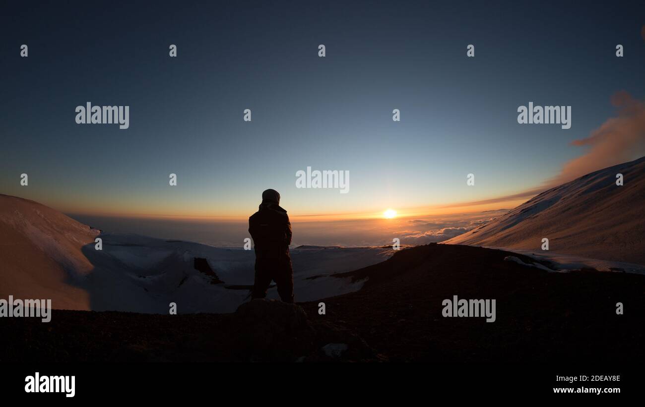 Un randonneur de silhouette regardant le coucher du soleil dans le rétroéclairage de l' Volcan Etna à l'heure d'or-Sicile Banque D'Images