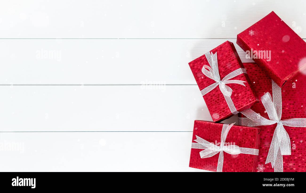 Groupe de boîtes-cadeaux rouges de Noël à la bordure blanche arrière-plan de panneau en bois avec espace de copie Banque D'Images