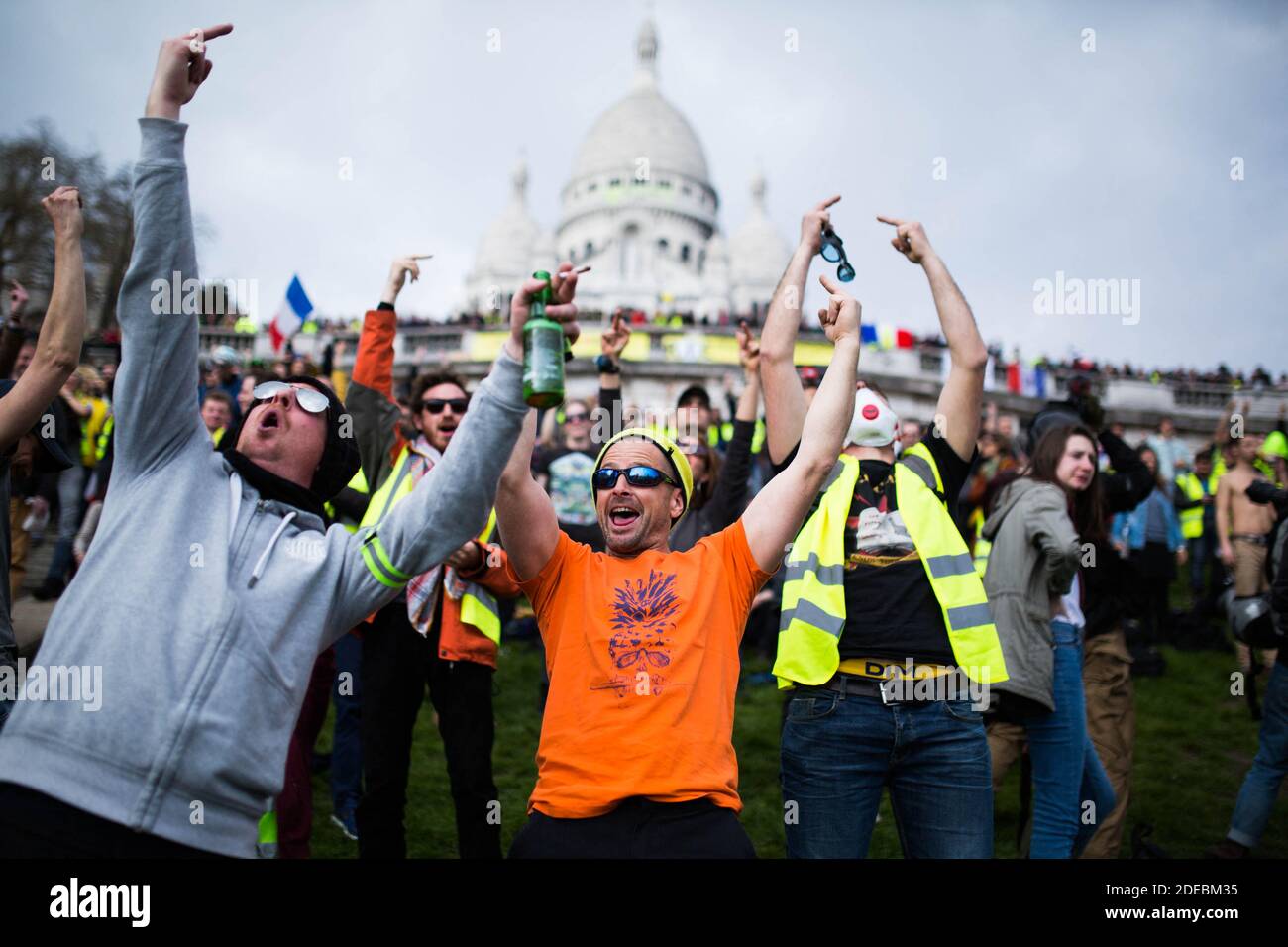 Les manifestants de la Yellow Vest se rassemblent devant la basilique du Sacré-cœur à Montmartre et saluent un doigt un hélicoptère de police, à Paris, le 23 mars 2019, lors d'une manifestation antigouvernementale appelée par le mouvement de la « Yellow Vest » (gilets jaunes). Les manifestants ont de nouveau frappé les rues des villes françaises le 23 mars, pour une 19e semaine consécutive de protestation nationale ( Loi 19 ) contre les politiques du président français et son style de gouvernement descendant, le coût élevé de la vie, les réformes fiscales gouvernementales et pour une plus grande « justice sociale et économique. » photo de Raphael Lafargue/ABACAPRESS.COM Banque D'Images