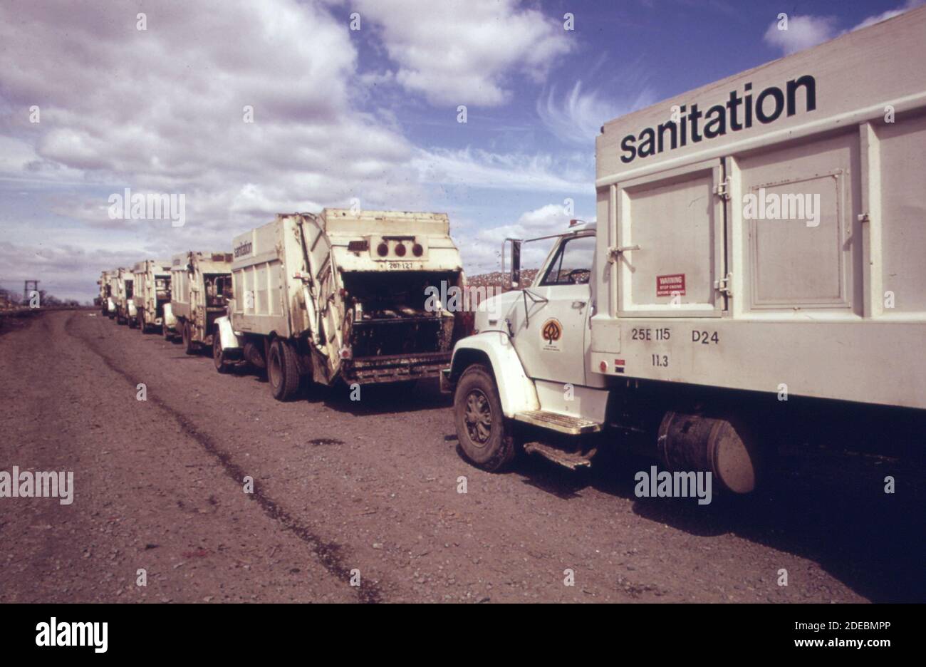 Photo des années 1970 - (1973) - procession de camions transportant des déchets À un dépotoir de ville déjà débordant dans le Bronx Banque D'Images