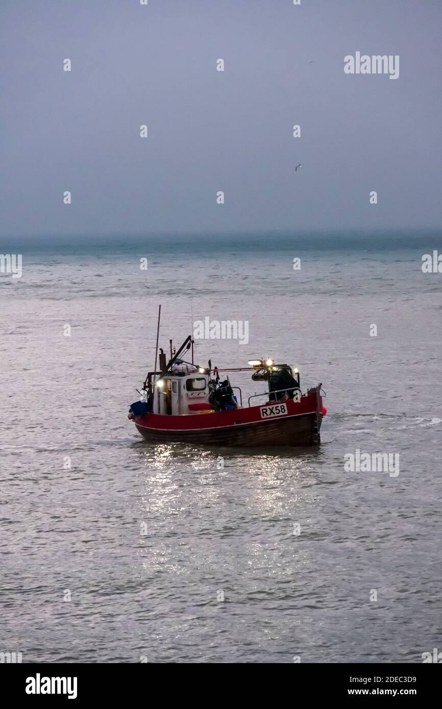 Le bateau de pêche Hastings se délarant à l'aube pour pêcher dans la Manche, East Sussex, Royaume-Uni Banque D'Images