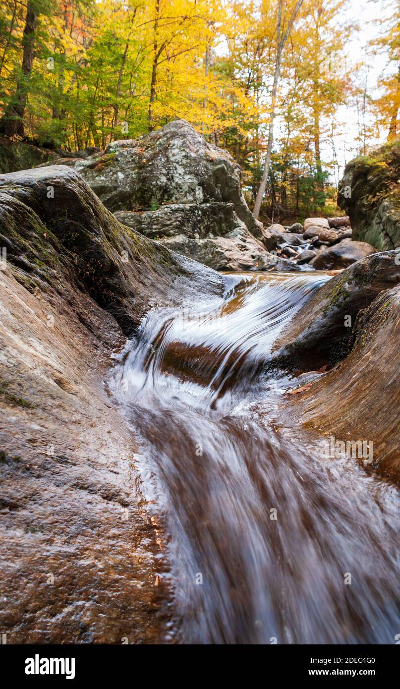 Ruisseau qui coule à travers une gouttière en pierre sculptée dans le soubassement. Mad River, Warren, Vermont, États-Unis. Banque D'Images