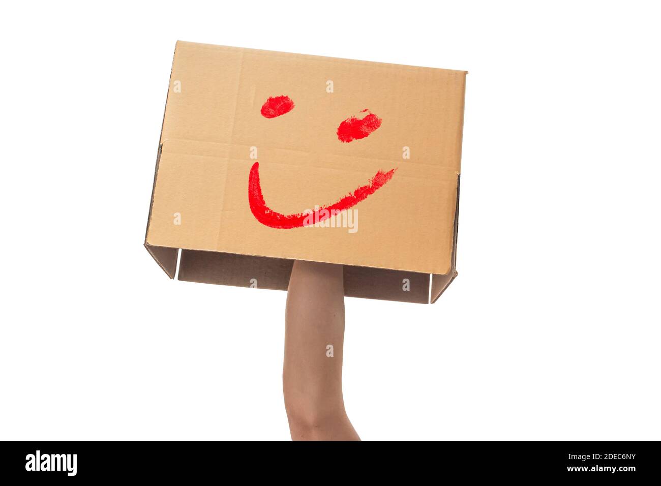 main tenant une boîte en carton avec une smiley face isolée sur fond blanc. avec un chemin d'écrêtage. Banque D'Images