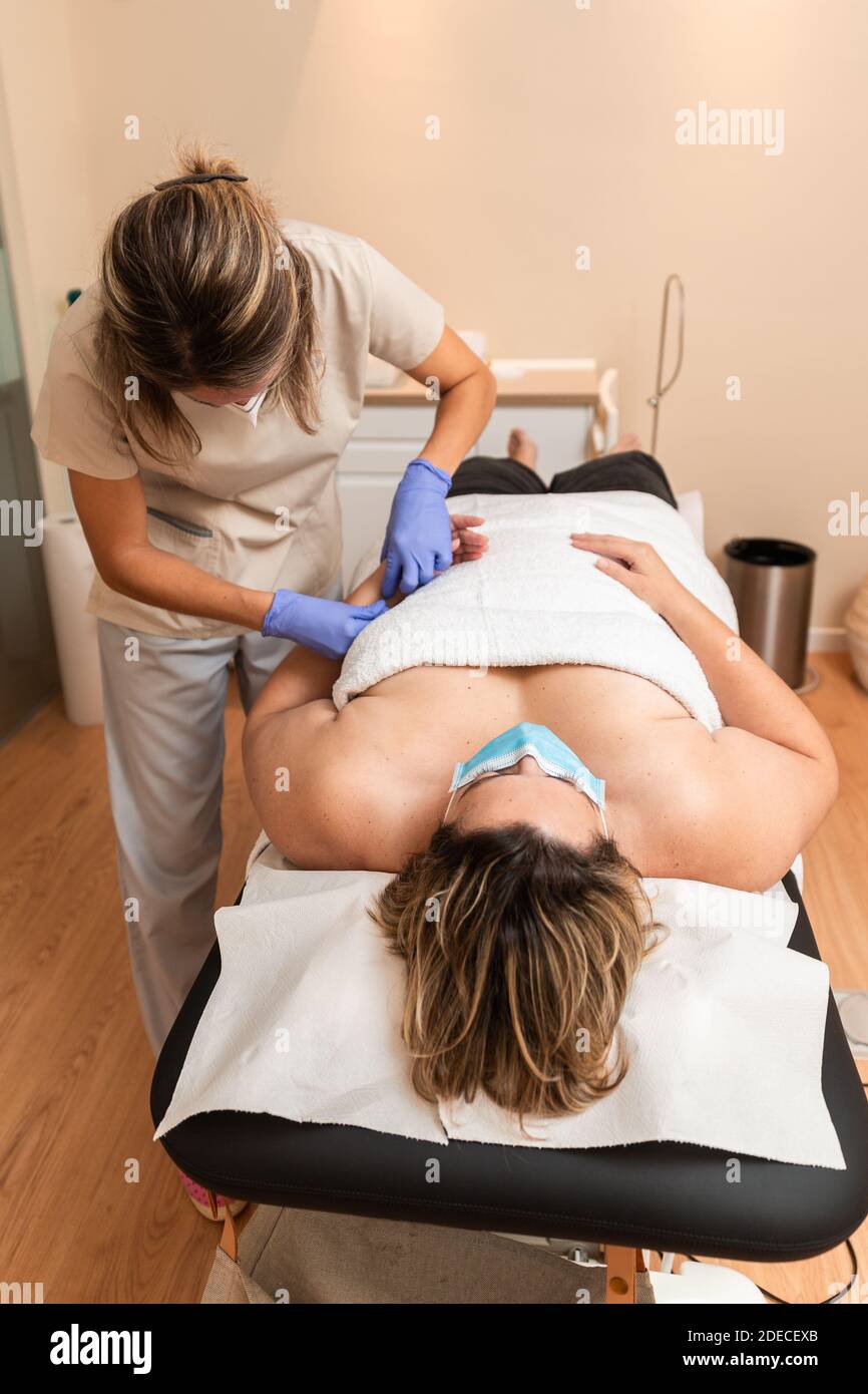 kinésithérapeute donnant le traitement avec l'acupuncture à aiguille sèche au patient dedans les mains Banque D'Images