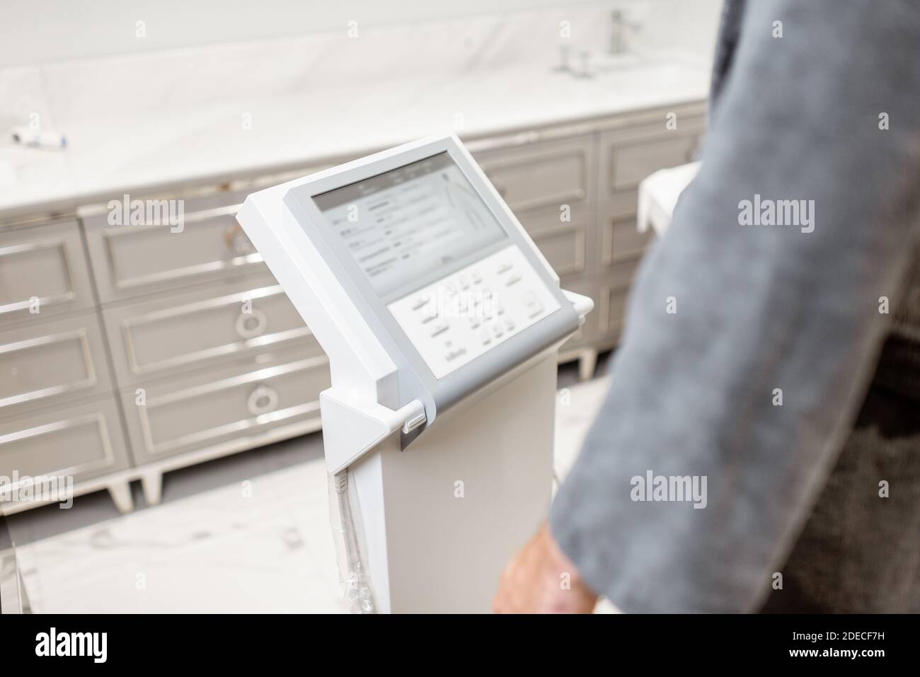 Homme mesurant l'équilibre de composition corporelle, tenant les poignées d'une balance médicale pendant le test d'organisme Banque D'Images