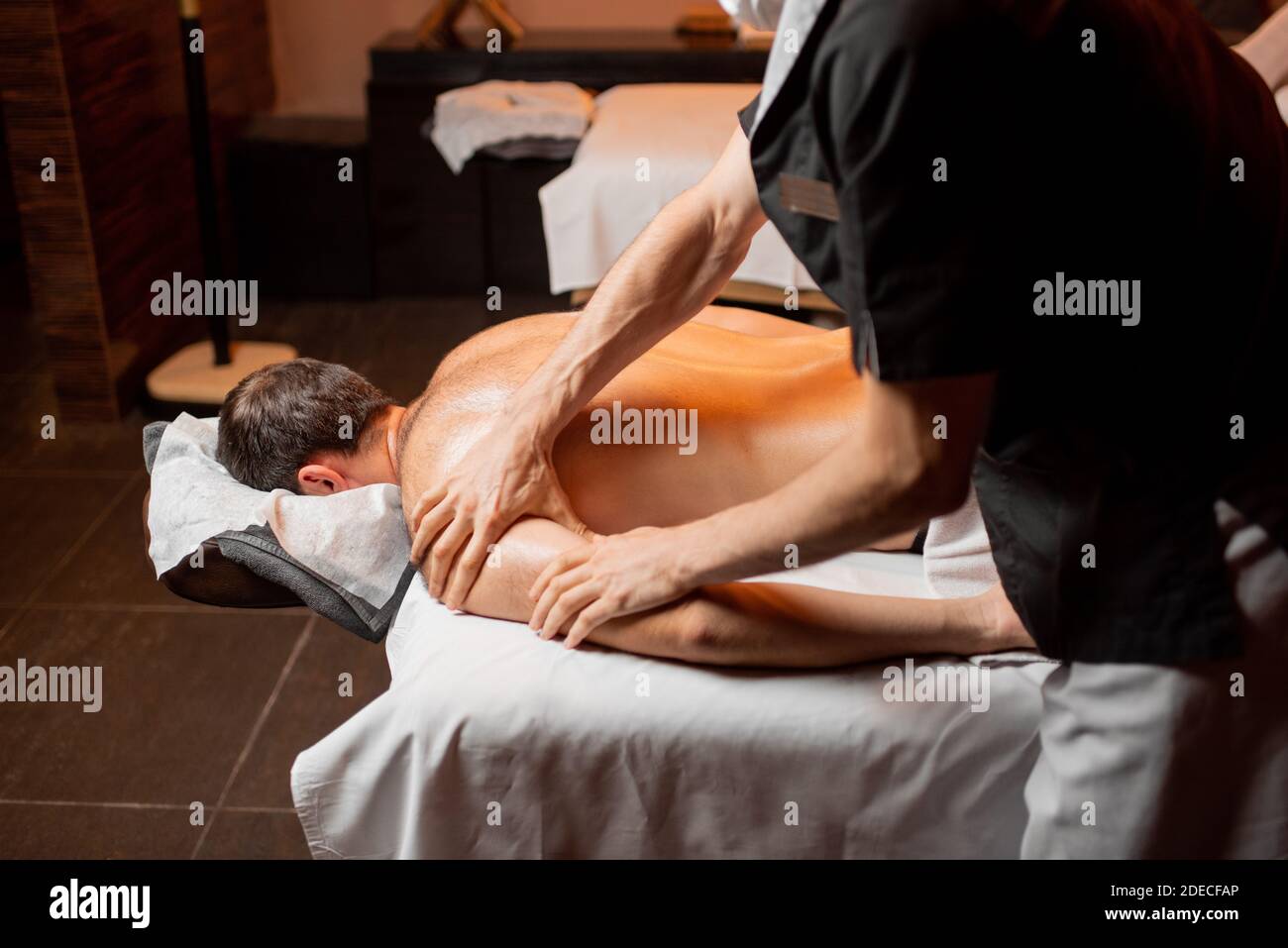 Homme recevant un massage profond sur son dos de professionnel thérapeute au luxueux spa Banque D'Images