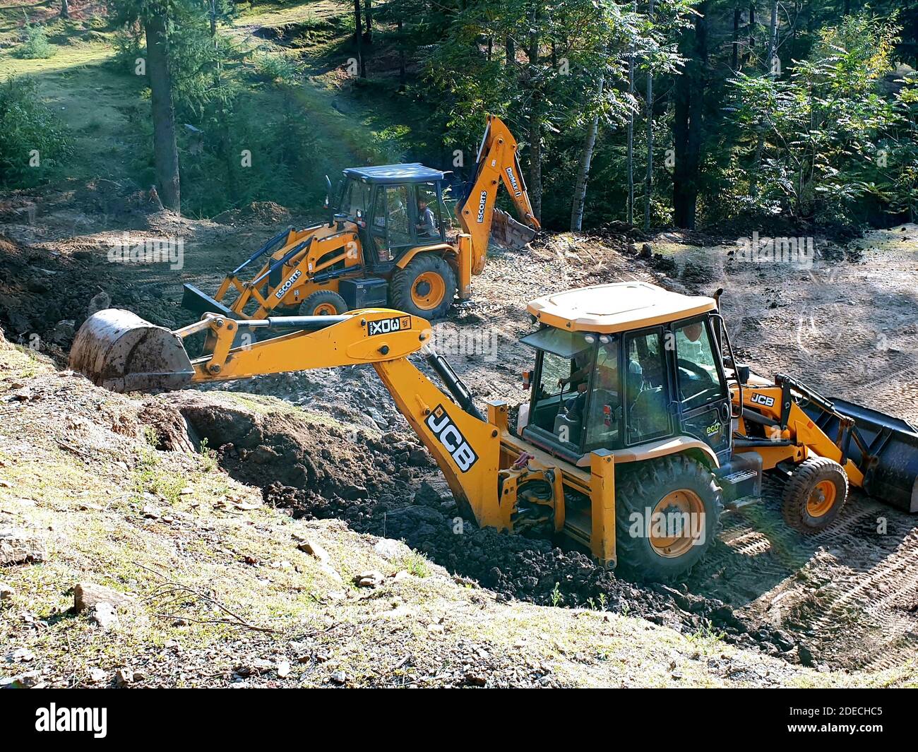 JCB travaille à construire un terrain de jeu dans une zone rurale de hyhama kupwara jammu-et-cachemire. La forêt est également en arrière-plan 2019 Banque D'Images