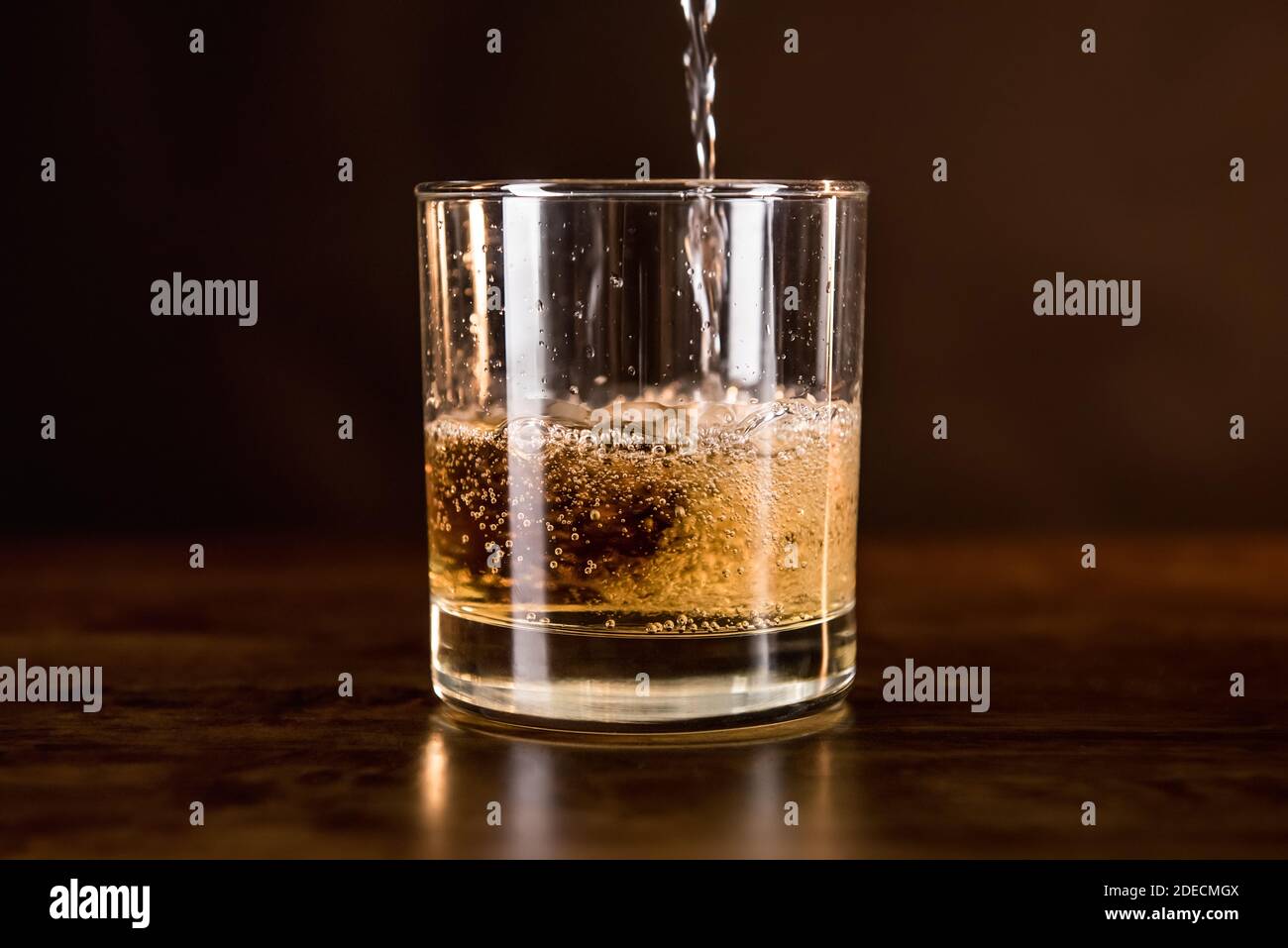 Boisson de whisky versée dans le verre sur bois bar du comptoir - concept de boissons alcoolisées et spiritueux Banque D'Images