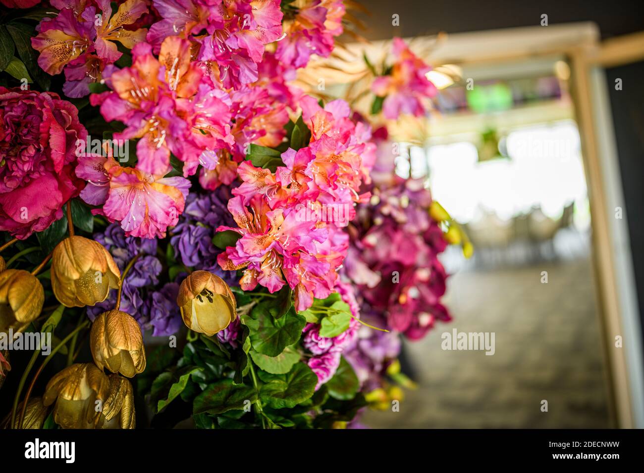 Gros plan d'un bouquet de fleurs roses, rouges et dorées avec un arrière-plan flou Banque D'Images