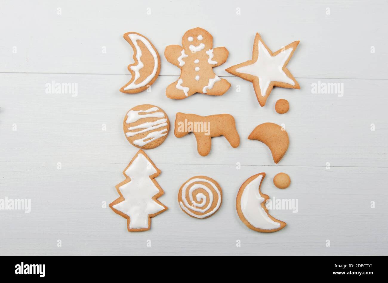 Biscuits de noël faits maison avec glaçage sur fond de bois blanc Banque D'Images