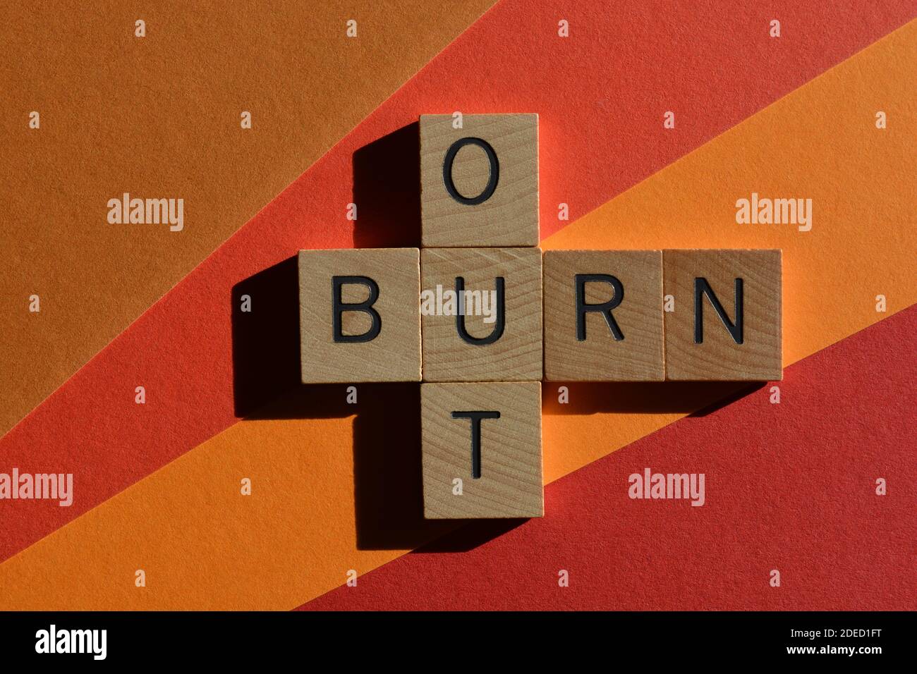 Brûlez, les mots en lettres de l'alphabet en bois en forme de mots croisés isolés sur fond coloré Banque D'Images