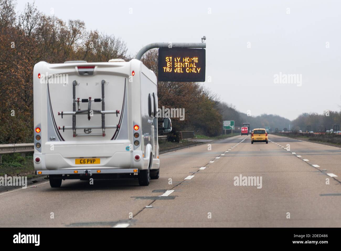 Signe matriciel avec message d'avertissement du coronavirus du gouvernement Restez à la maison, voyage essentiel seulement, sur A12, Essex, Royaume-Uni, avec un campervan sur la route Banque D'Images