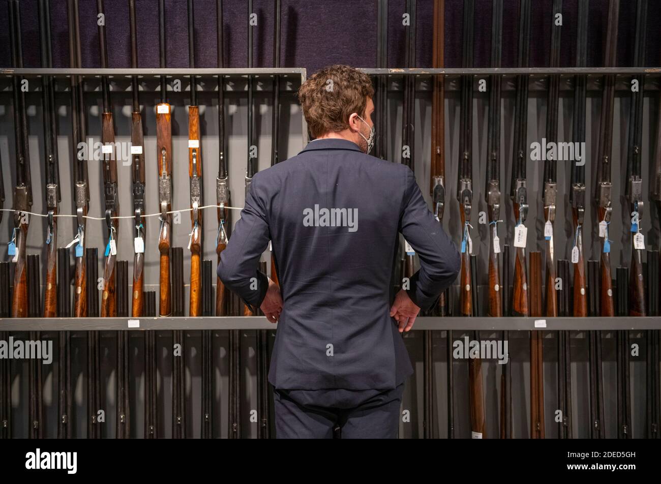 Knightsbridge, Londres, Royaume-Uni. 30 novembre 2020. Aperçu de la vente d'armes anciennes, d'armes de sport modernes et d'armes à feu exceptionnelles de Bonhams à Londres. La vente aura lieu le 3 décembre. Image: Le membre du personnel de Bonhams regarde le long des racks de fusils de chasse exposés pour la vente. Crédit : Malcolm Park/Alay Live News Banque D'Images