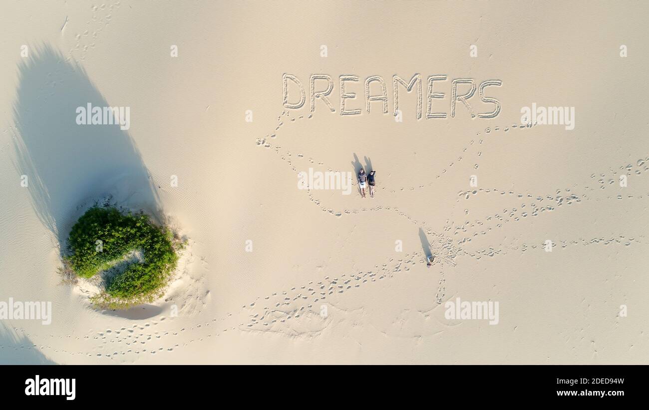couple se posant sur la belle plage de sable blanc, les rêveurs s'écritent sur la vue de l'oiseau de sable Banque D'Images