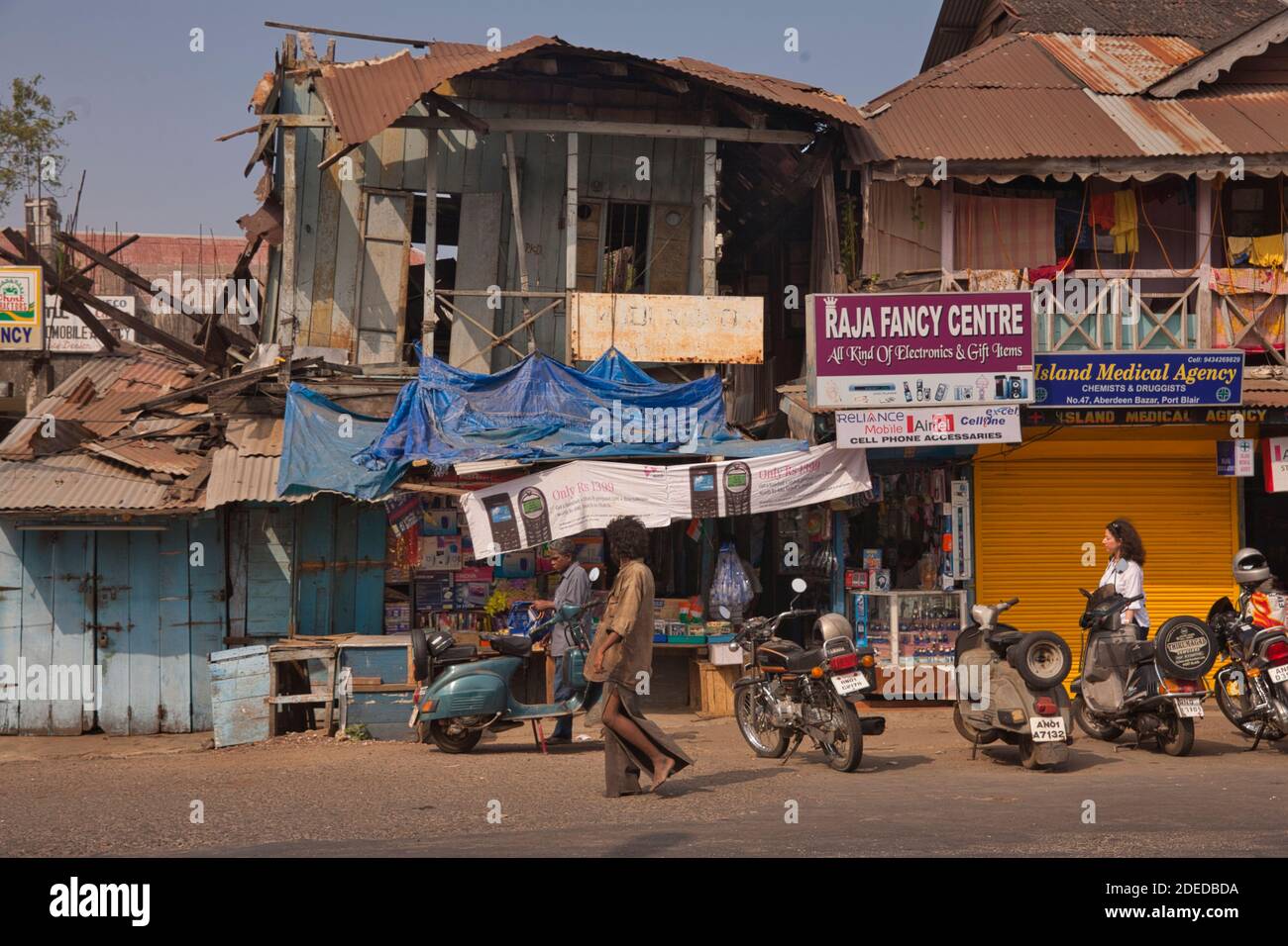 Activité sur la rue principale de Port Blair dans les îles Andaman avec des façades de magasins et des gens passant par, une scène typique de pays du tiers monde Banque D'Images