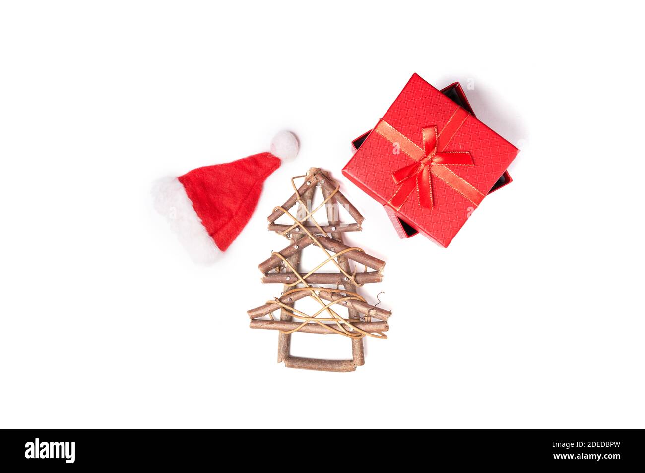 Sapin de Noël en bois, chapeau de Noël et cadeau rouge sur fond blanc isolé avec espace de copie Banque D'Images