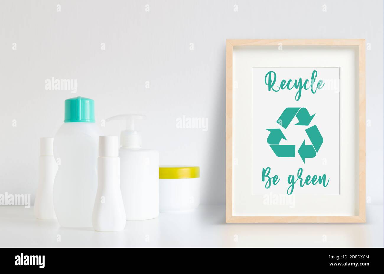 Quelques bouteilles en plastique prêtes à être recyclées à côté d'un cadre avec logo de recyclage. Banque D'Images