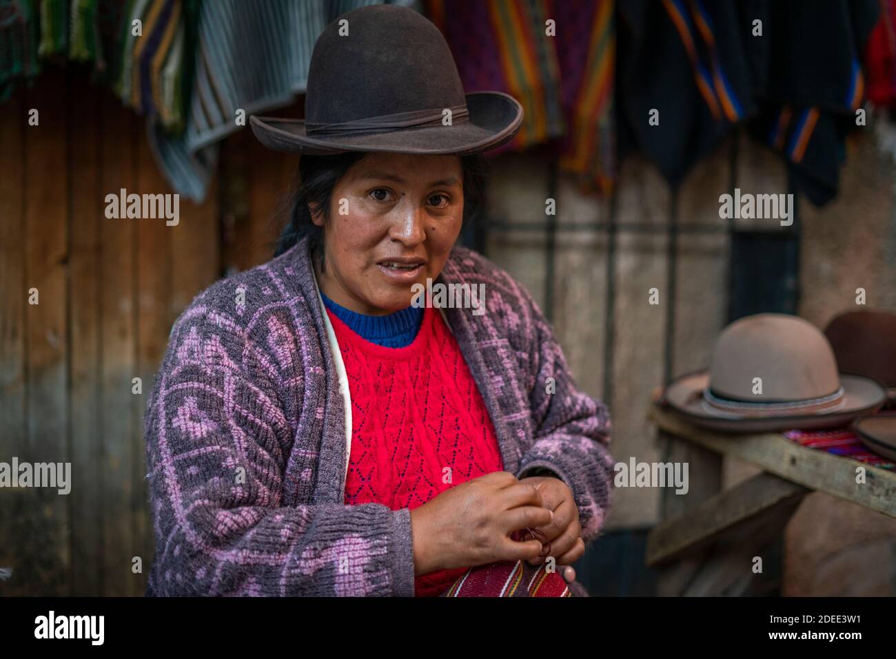 Femme vendant des chapeaux et des vêtements sur le marché à Pisac (Pisaq), Vallée Sacrée, Cusco, Pérou Banque D'Images