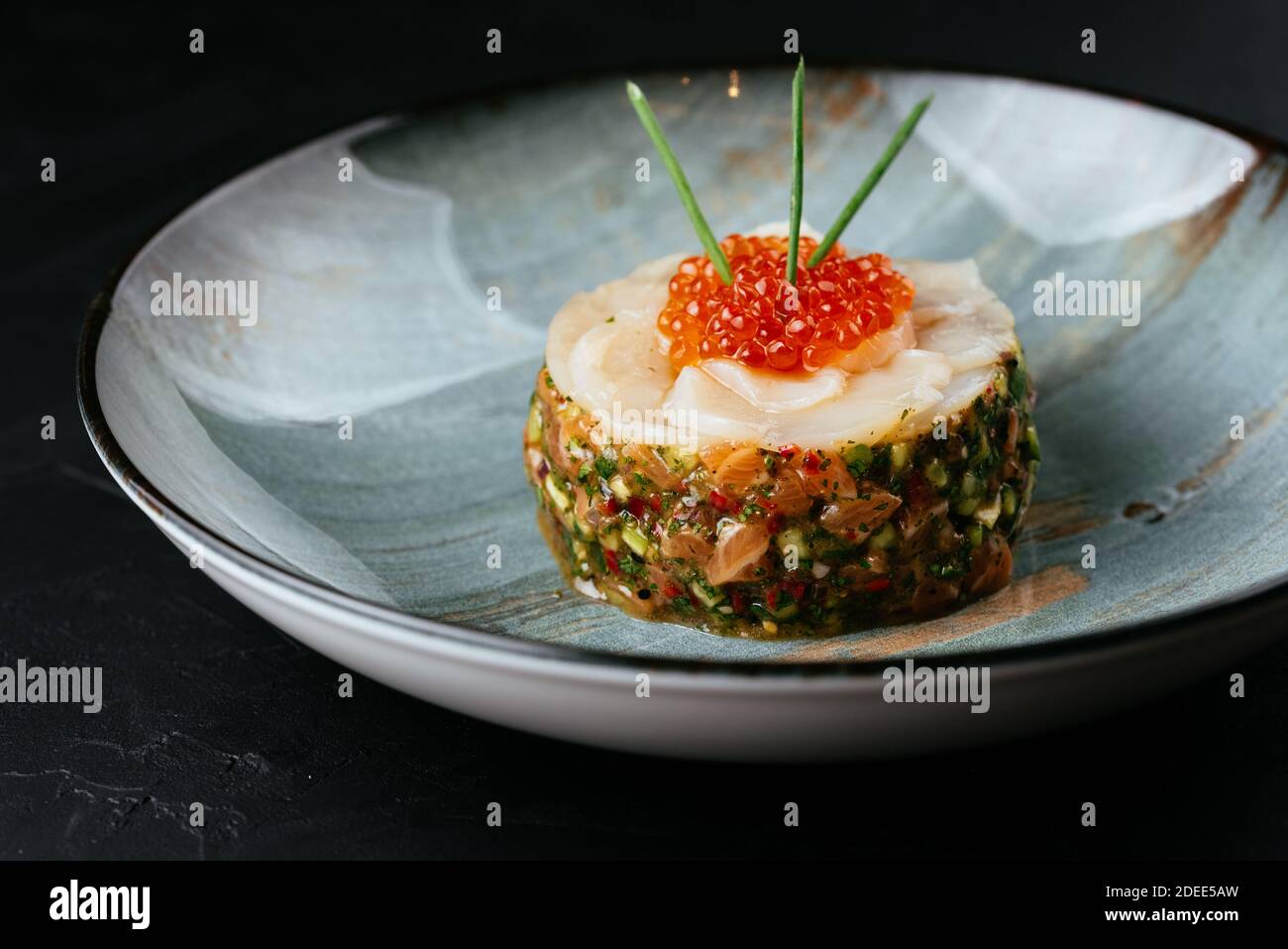 tartare de saumon frais avec caviar rouge sur fond noir Banque D'Images