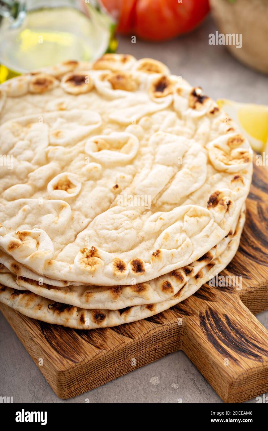 Une pile de pain pita sur une planche à découper Banque D'Images