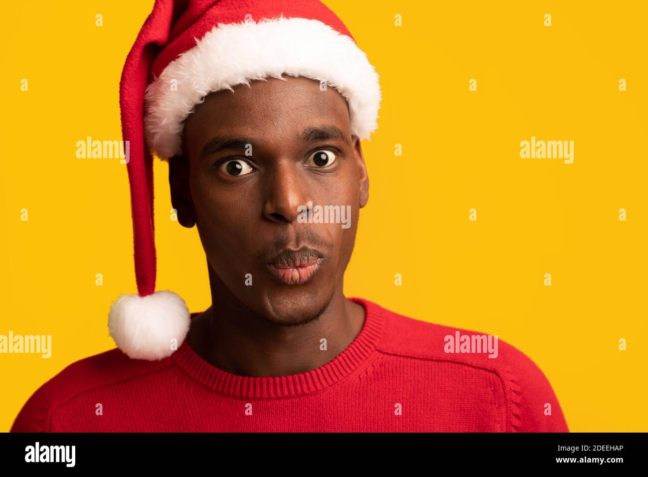 Stupéfait Black Guy de Santa Hat réagissant émotionnellement à choquant Offre de Noël Banque D'Images