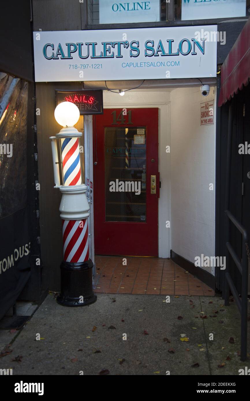 Entrée à un salon de coiffure avec un poteau de salon de coiffure traditionnel À l'entrée qui dit « coupes de cheveux » le long de la rue Montegue Le voisin de Brooklyn Heights Banque D'Images