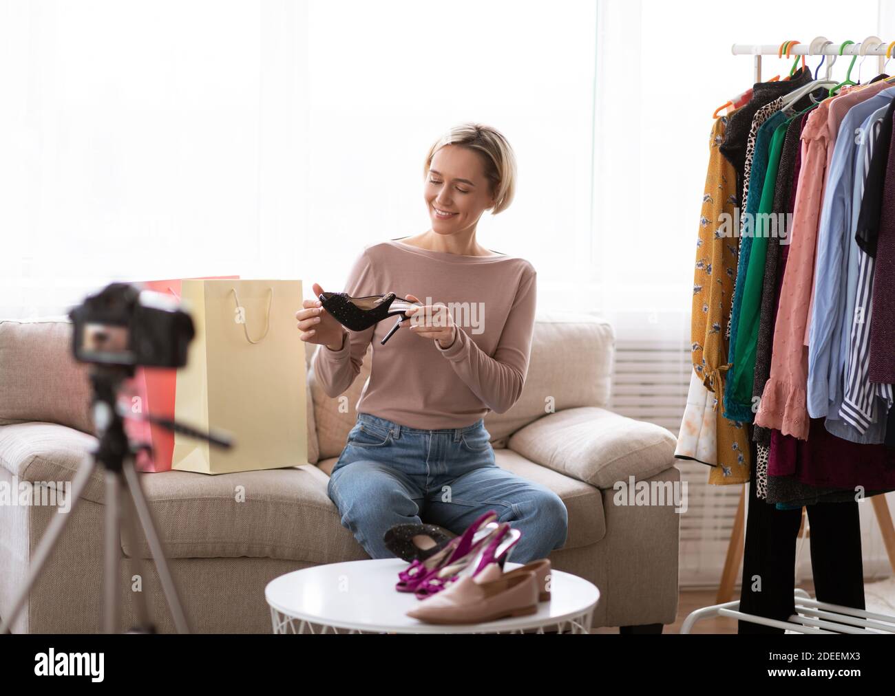 Happy Fashion blogger fait la vidéo sur les nouveaux vêtements et chaussures collection pour son vlog, le tournage de la critique sur caméra à la maison Banque D'Images