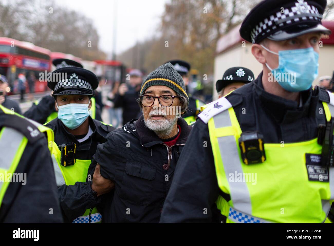 Manifestation anti-verrouillage, Hyde Park, Londres, 28 novembre 2020. Un manifestant âgé arrêté est emmené par des policiers sous un masque facial. Banque D'Images