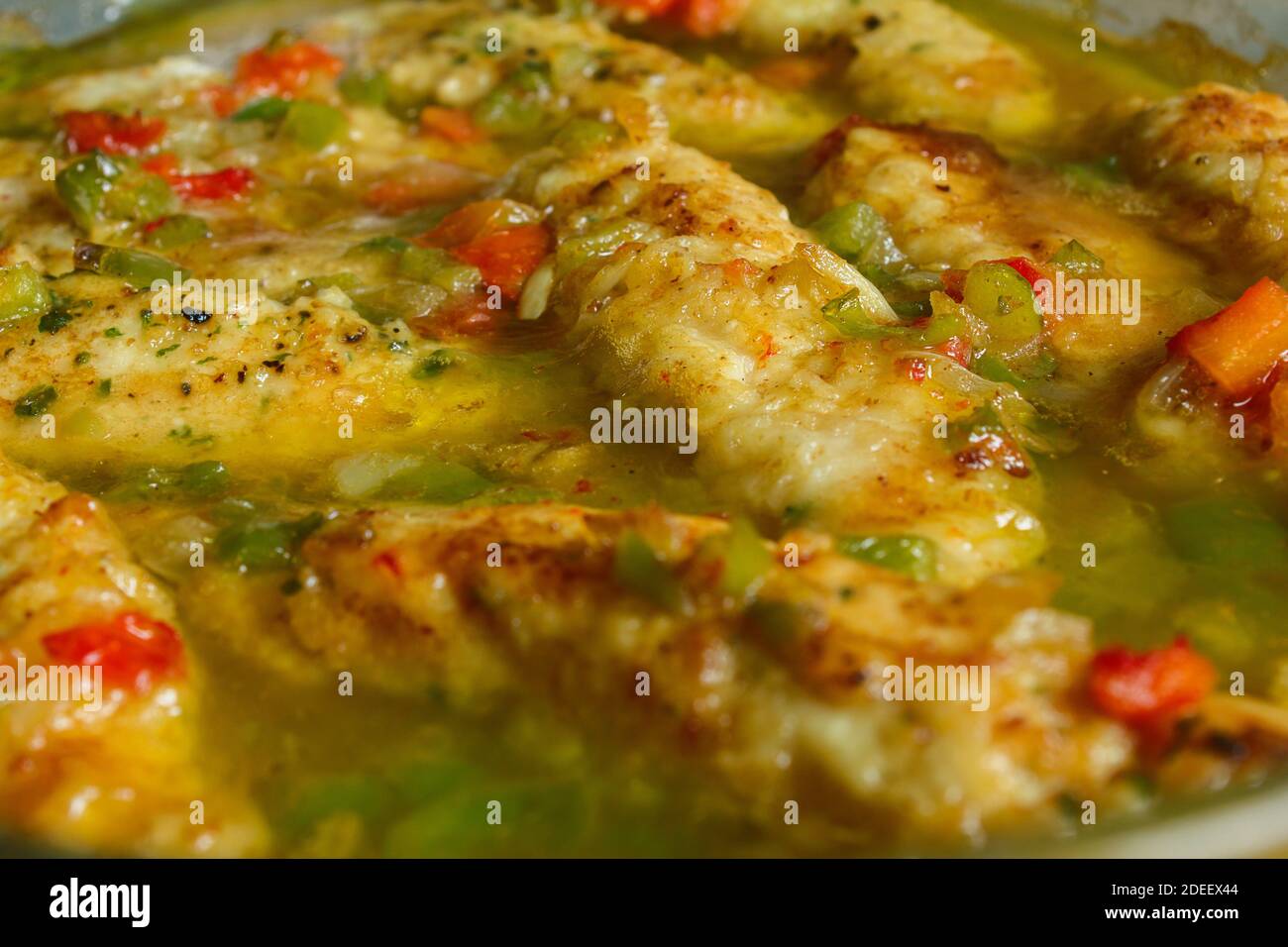 Gros plan d'un délicieux filet de poulet sauce verte avec persil, huile d'oignon et poivron rouge. Recettes de cuisine saines et faciles. Banque D'Images