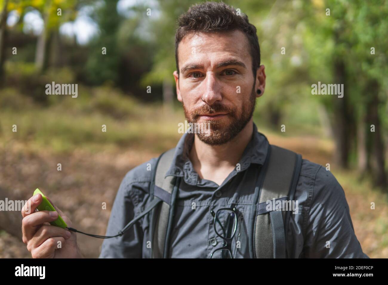 Un jeune homme en randonnée dans les montagnes, regardant un appareil photo avec un GPS dans ses mains. Concept de sport. Nature et environnement Banque D'Images