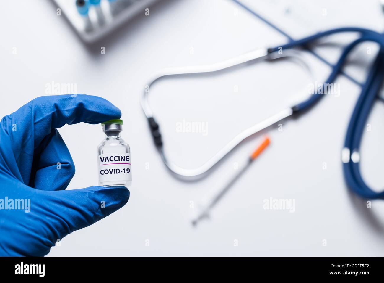 Main d'un médecin, d'un scientifique ou d'une infirmière en gants bleus tenant un flacon de vaccin contre le coronavirus pour les maladies vaccination contre les épidémies, médecine et concept de médicament Banque D'Images