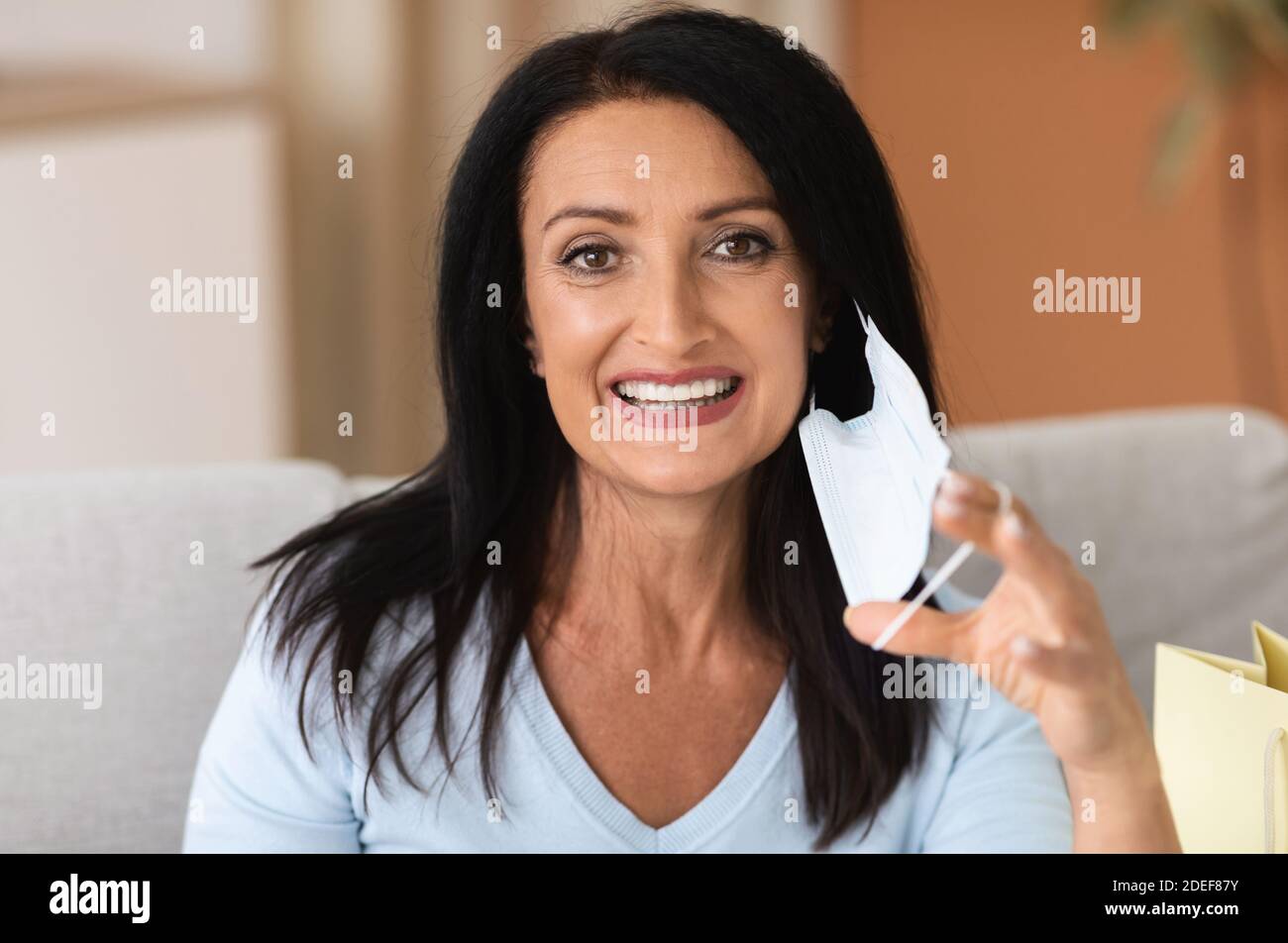 Portrait d'une femme mature qui prend un masque médical Banque D'Images