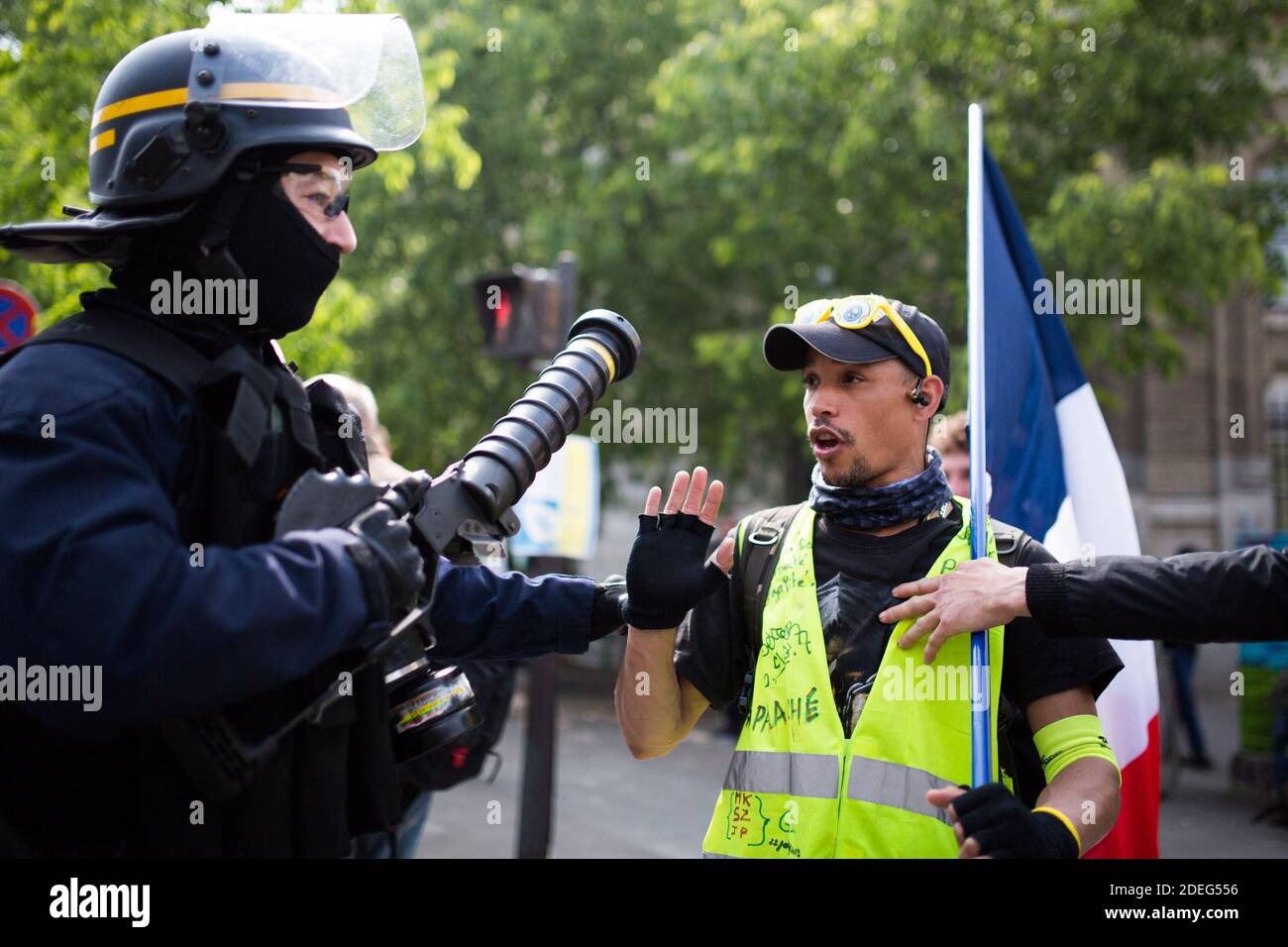 Le CRS de la police tient une arme à gaz lacrymogène pour discuter avec un gilet jaune de manifestant un drapeau français face à face lors du rassemblement annuel du jour de mai à Paris le 1er mai 2019. La police anti-émeute de Paris a tiré des gaz lacrymogène alors qu'ils se sont mis au point contre des manifestants de la ligne dure parmi des dizaines de milliers de manifestants du jour de mai, qui ont inondé la ville le 1er mai pour mettre à l'épreuve la politique de tolérance zéro de la France sur les violences de rue. Photo de Raphaël Lafargue/ABACAPRESS.COM Banque D'Images