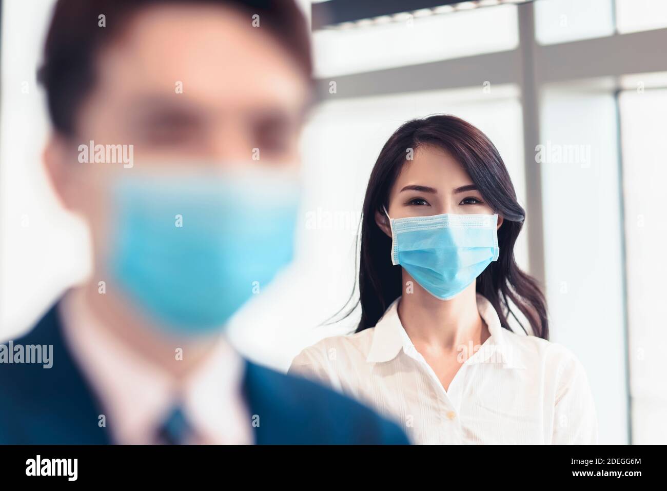 Homme d'affaires et femme portant un masque médical pendant le travail au bureau Banque D'Images