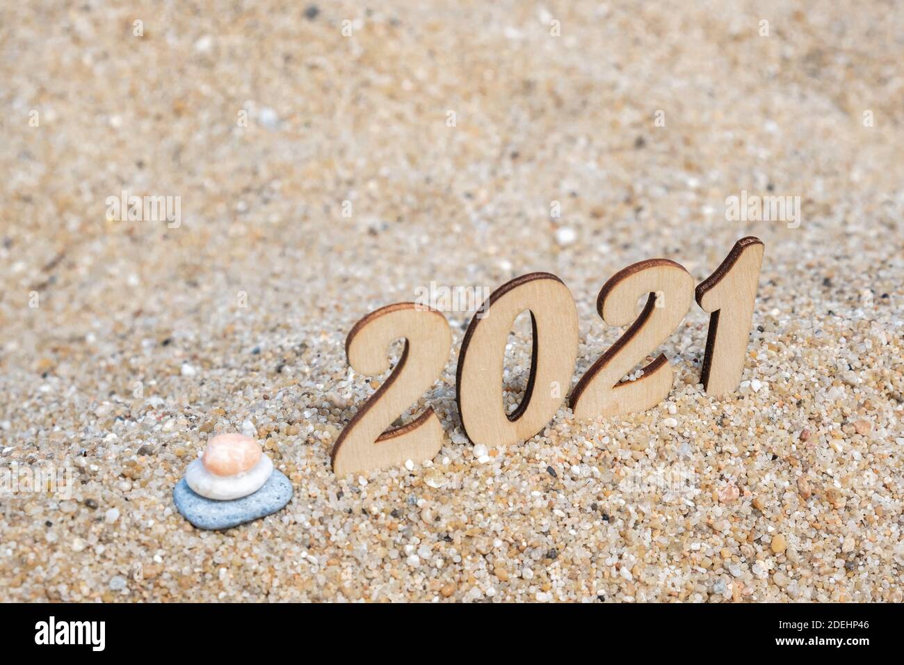 Carte de Noël créative. Le nouvel an numéros 2021 sur la plage au bord de la mer, cairn. Tourisme, loisirs et voyages. Copier l'espace. Mise au point sélective. Banque D'Images