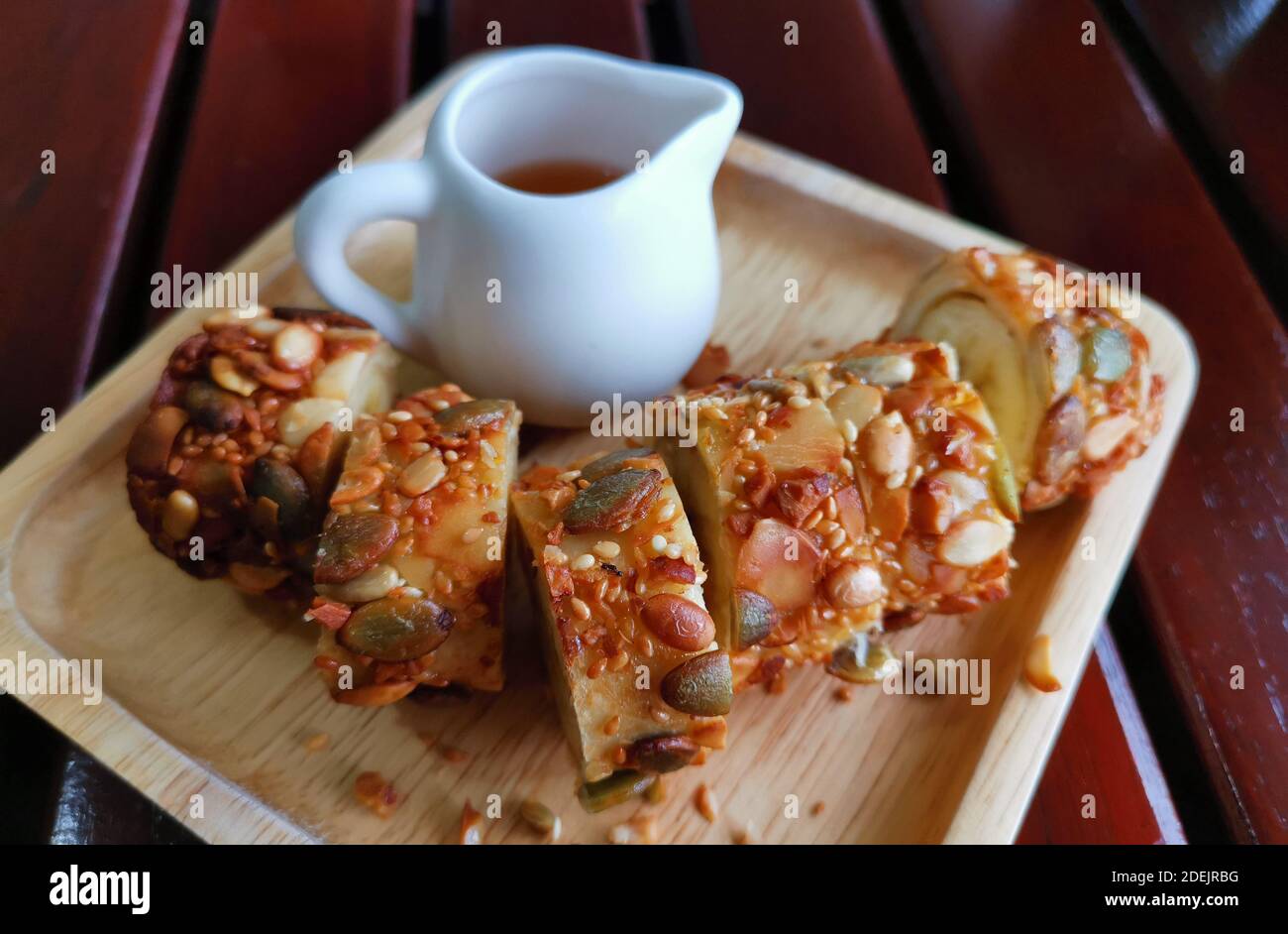 Crêpes enveloppées de banane et saupoudrées de noix servies avec miel Banque D'Images