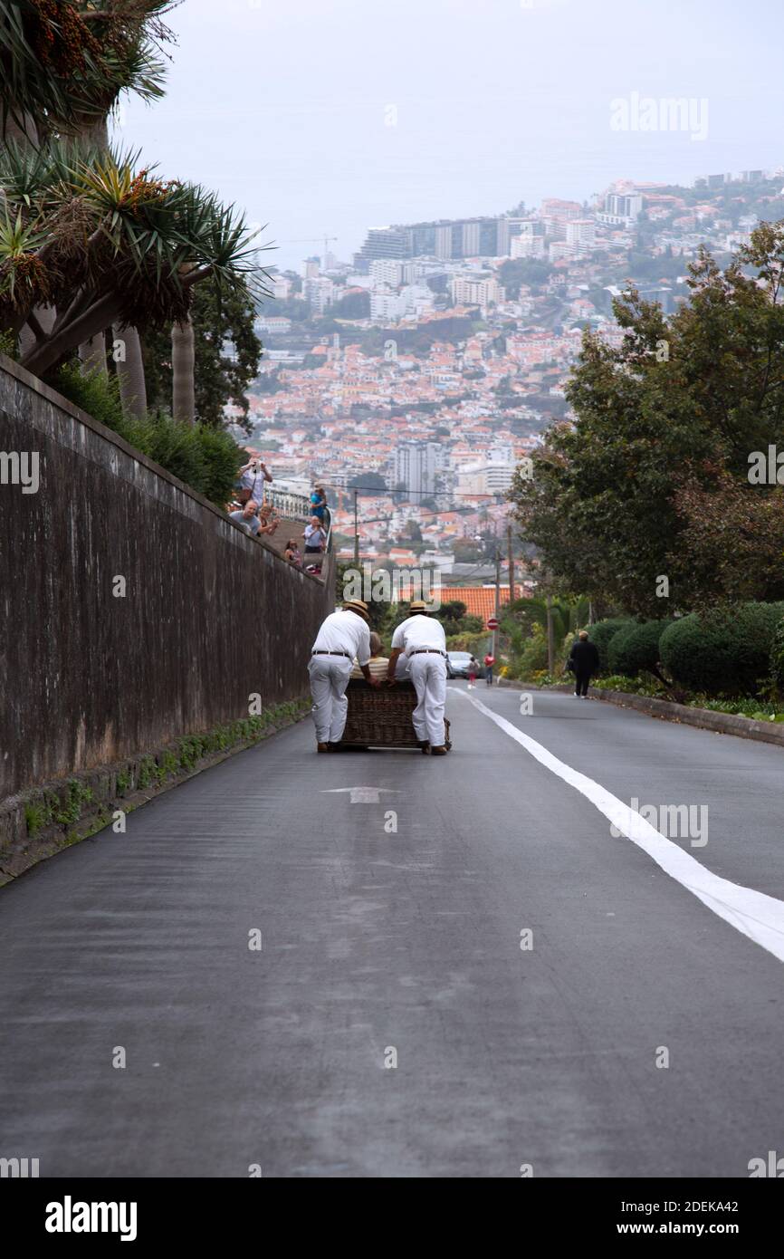 Carreiros do Monte pousse des traîneaux en osier vers le bas de la colline à Funchal, Madère Banque D'Images